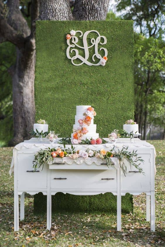 Expositor-de-postre-con-una-pared-floral-y-monograma-min