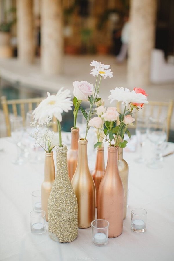 Centro de mesa de bricolaje con botellas de oro y cobre.